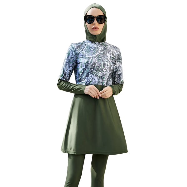 Une femme portant un maillot de bain musulman vert avec un motif floral blanc et vert.