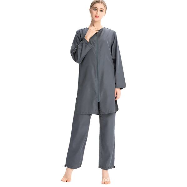 Une femme portant un ensemble de vêtements de bain musulman gris avec une fermeture éclair sur le devant.  Les vêtements sont longs et amples, couvrant le corps de la tête aux pieds.