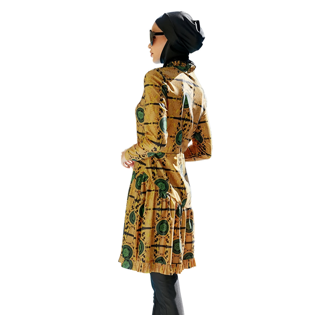 Une femme portant un hijab noir et une robe de bain islamique jaune à motifs verts.