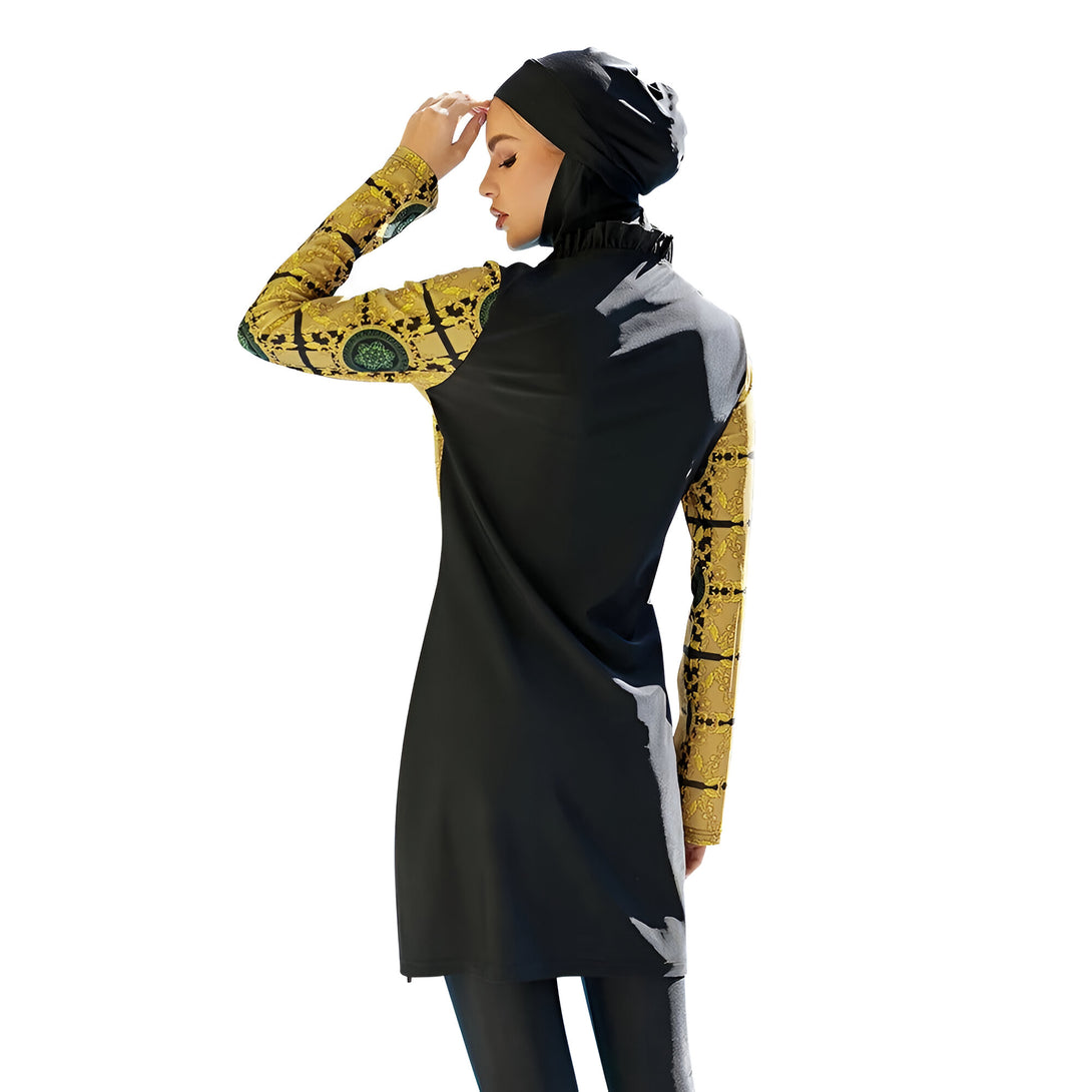 Une femme portant un maillot de bain musulman noir et jaune avec un motif floral. Le maillot de bain a des manches longues et une jupe longue. La femme porte un hijab noir.