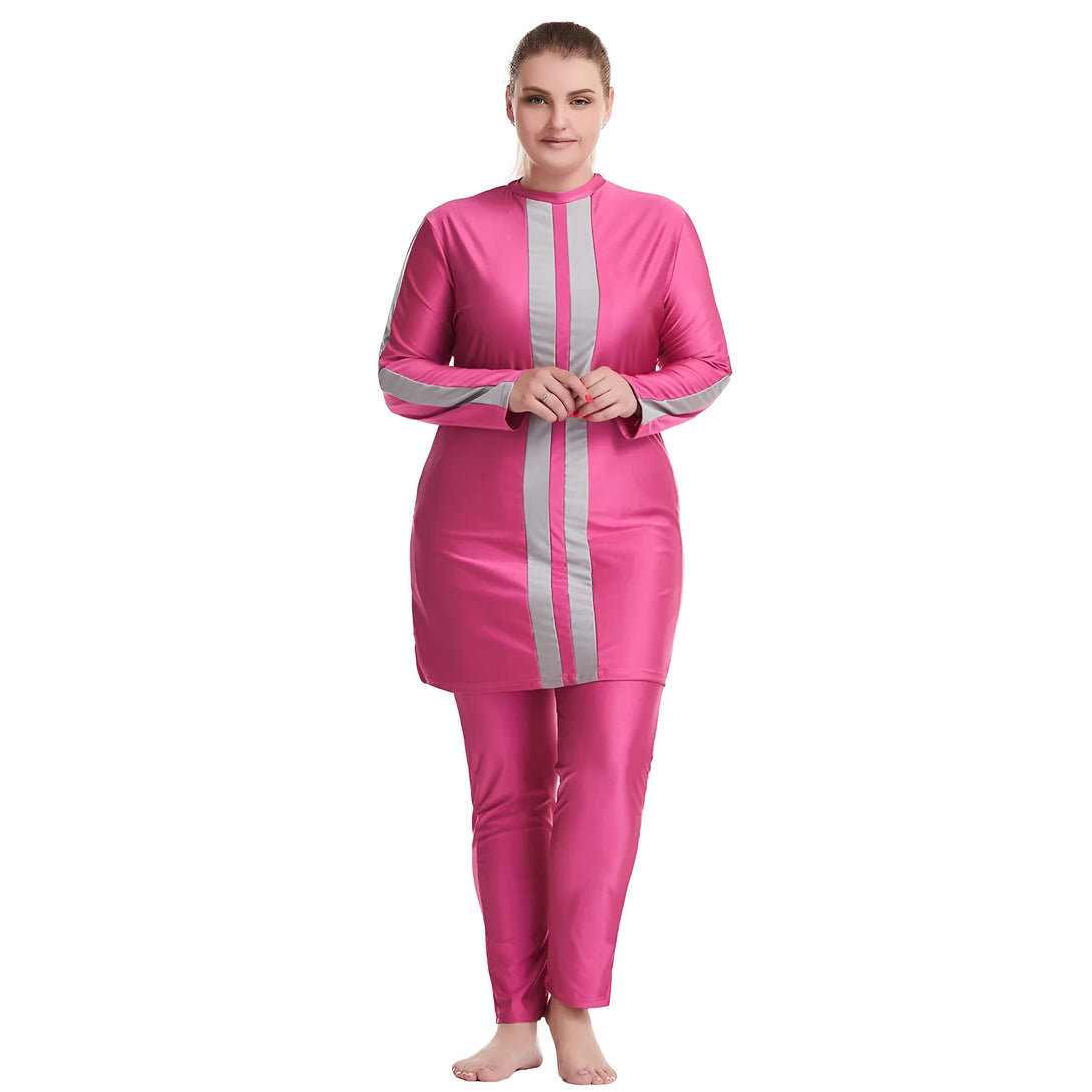 Une femme porte un maillot de bain islamique rose avec des rayures grises. Le maillot de bain est à manches longues et comprend un pantalon long.