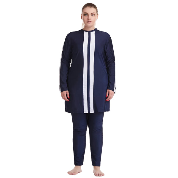 Une femme porte un maillot de bain musulman bleu marine avec des rayures blanches. Le maillot de bain est à manches longues et comprend un pantalon long.