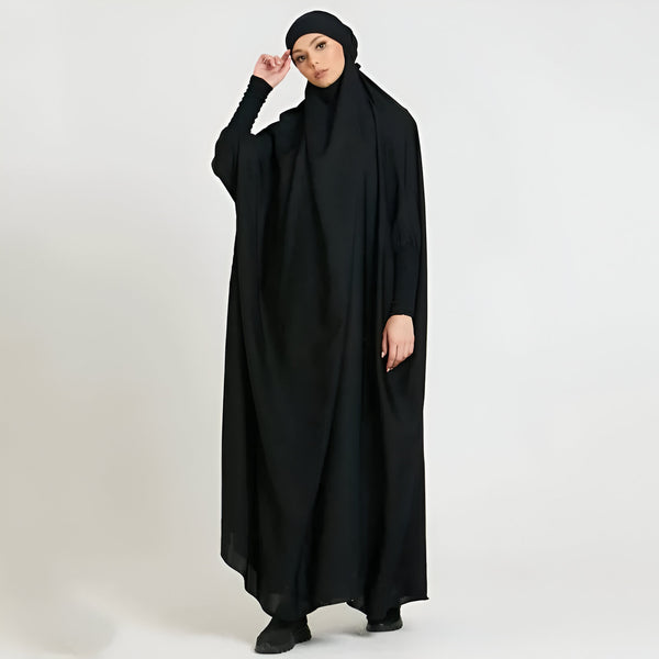 Une femme portant une abaya noire avec un hijab assorti. La tenue est élégante et confortable, parfaite pour les femmes musulmanes.