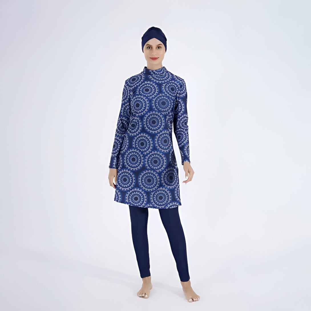 Une femme portant un maillot de bain musulman bleu avec un motif de cercles. Elle porte également un hijab bleu.