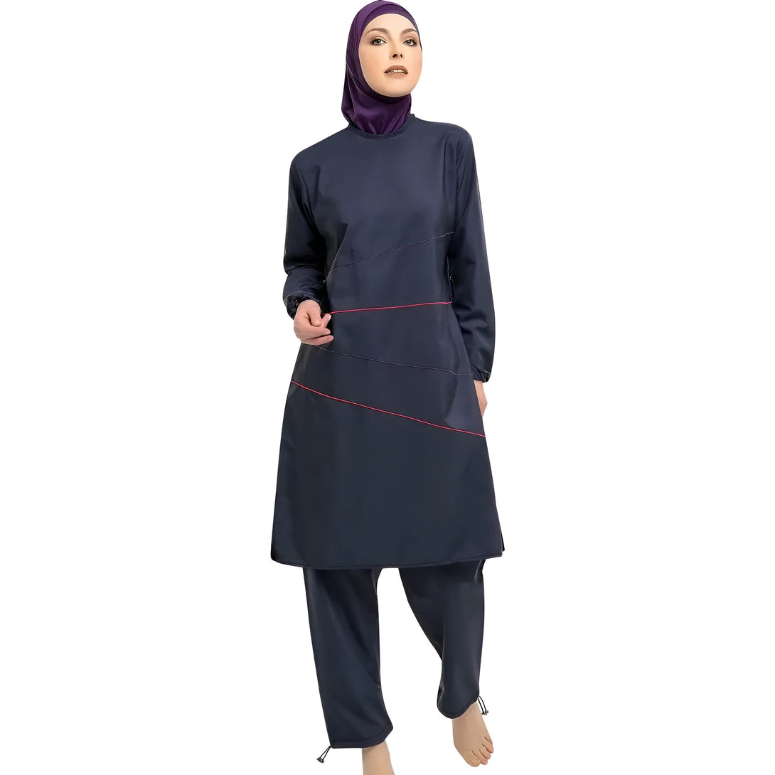Une femme portant un hijab violet et un maillot de bain musulman bleu marine avec des détails rouges.