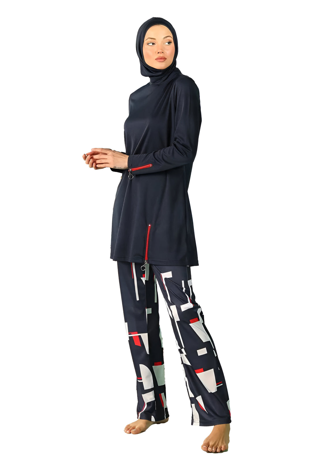 Une femme portant un maillot de bain musulman bleu marine avec des détails rouges et des pantalons imprimés géométriques noir, blanc et rouge.