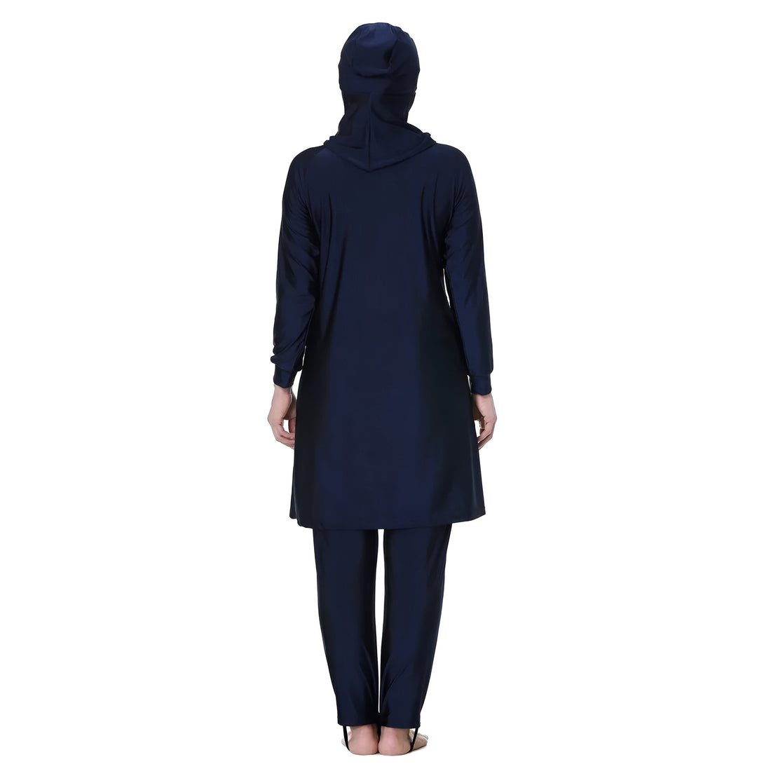 Une femme portant un maillot de bain musulman bleu marine, avec une tunique et un pantalon assortis, et un hijab assorti.