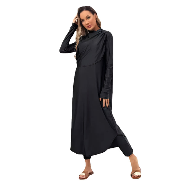 Une femme porte une longue robe noire musulmane avec un col montant. La robe est ample et fluide, avec des manches longues. La femme porte des sandales plates.