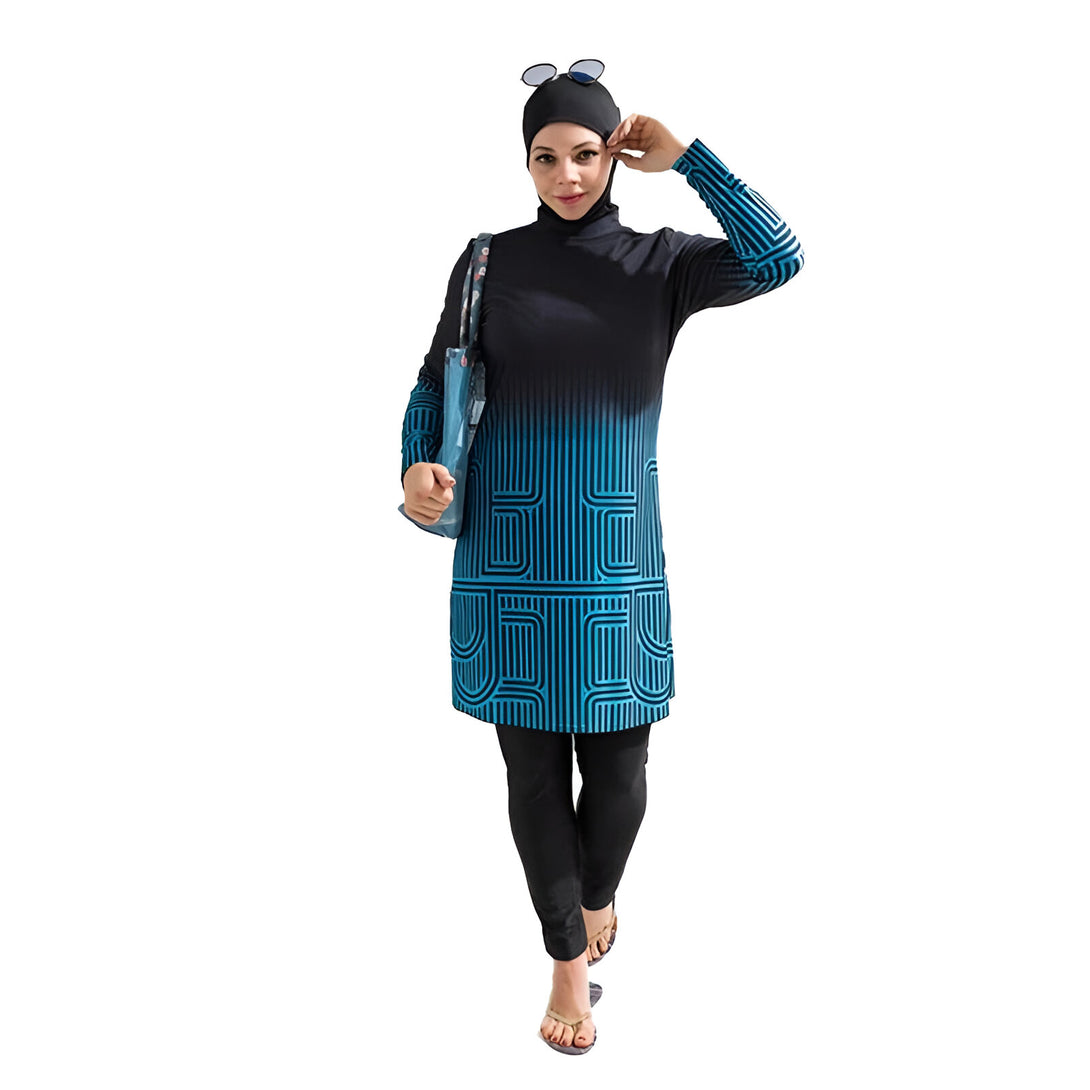 Une femme portant un maillot de bain musulman noir et bleu avec un motif géométrique. Elle porte également un hijab noir et des lunettes de soleil.