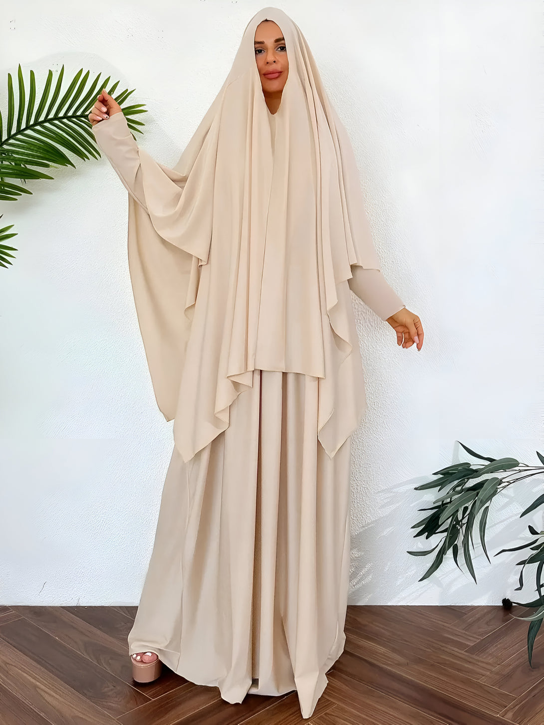 Une femme portant une robe beige ample et élégante avec un hijab assorti. La robe est de style ample et fluide, parfaite pour les occasions spéciales ou quotidiennes.