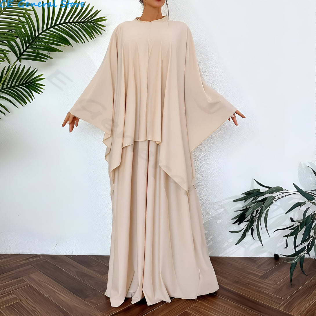 Une femme porte une robe longue beige à manches longues et une jupe ample, idéale pour les occasions spéciales.