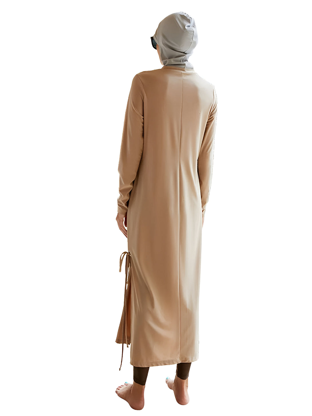 Une femme portant un hijab et une robe de bain longue de couleur beige. La robe a des liens sur les côtés.