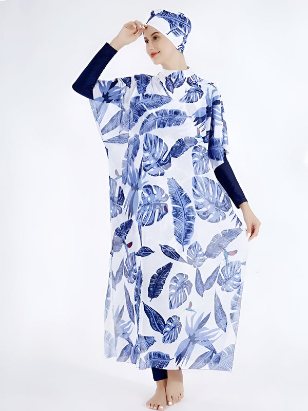 Une femme portant un maillot de bain musulman avec un motif de feuilles bleues sur fond blanc, comprenant un hijab assorti.