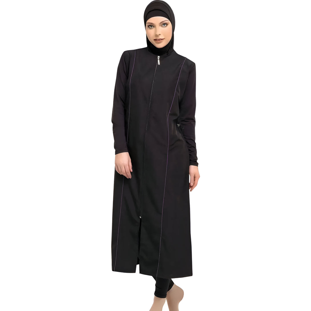 Une femme portant un maillot de bain musulman noir à fermeture éclair. Le maillot de bain est long et a des détails en violet.