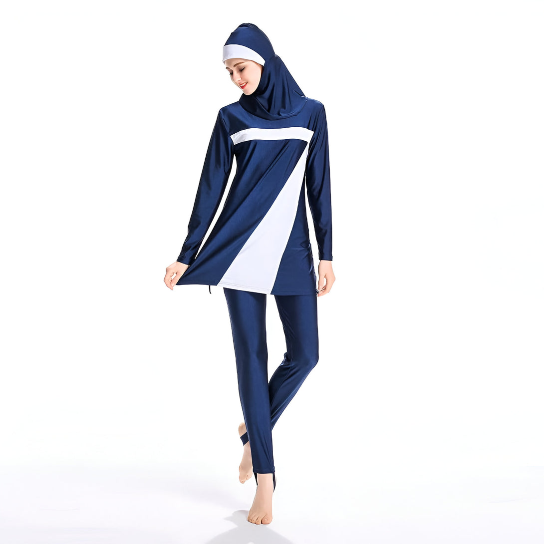 Une femme portant un maillot de bain musulman bleu marine et blanc avec un hijab assorti.