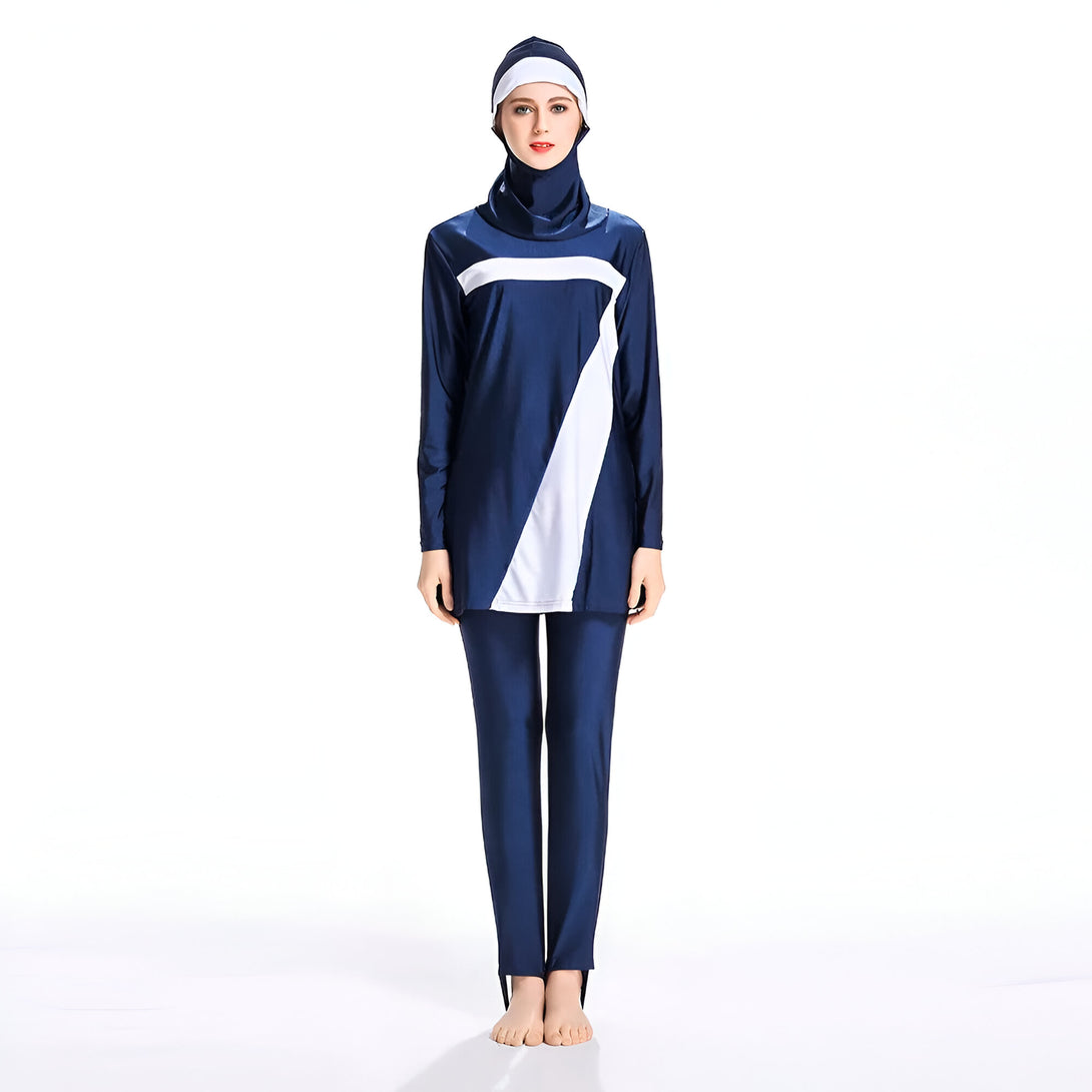 Une femme portant un maillot de bain musulman bleu marine et blanc avec un hijab assorti. Le maillot de bain a des manches longues et des pantalons longs.