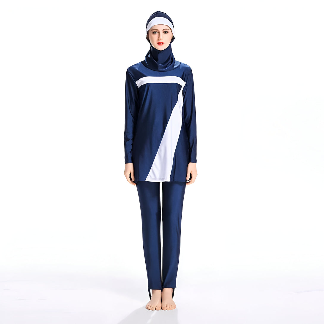 Une femme portant un maillot de bain musulman bleu marine avec des détails blancs. Le maillot de bain comprend une tunique à manches longues et un pantalon long.