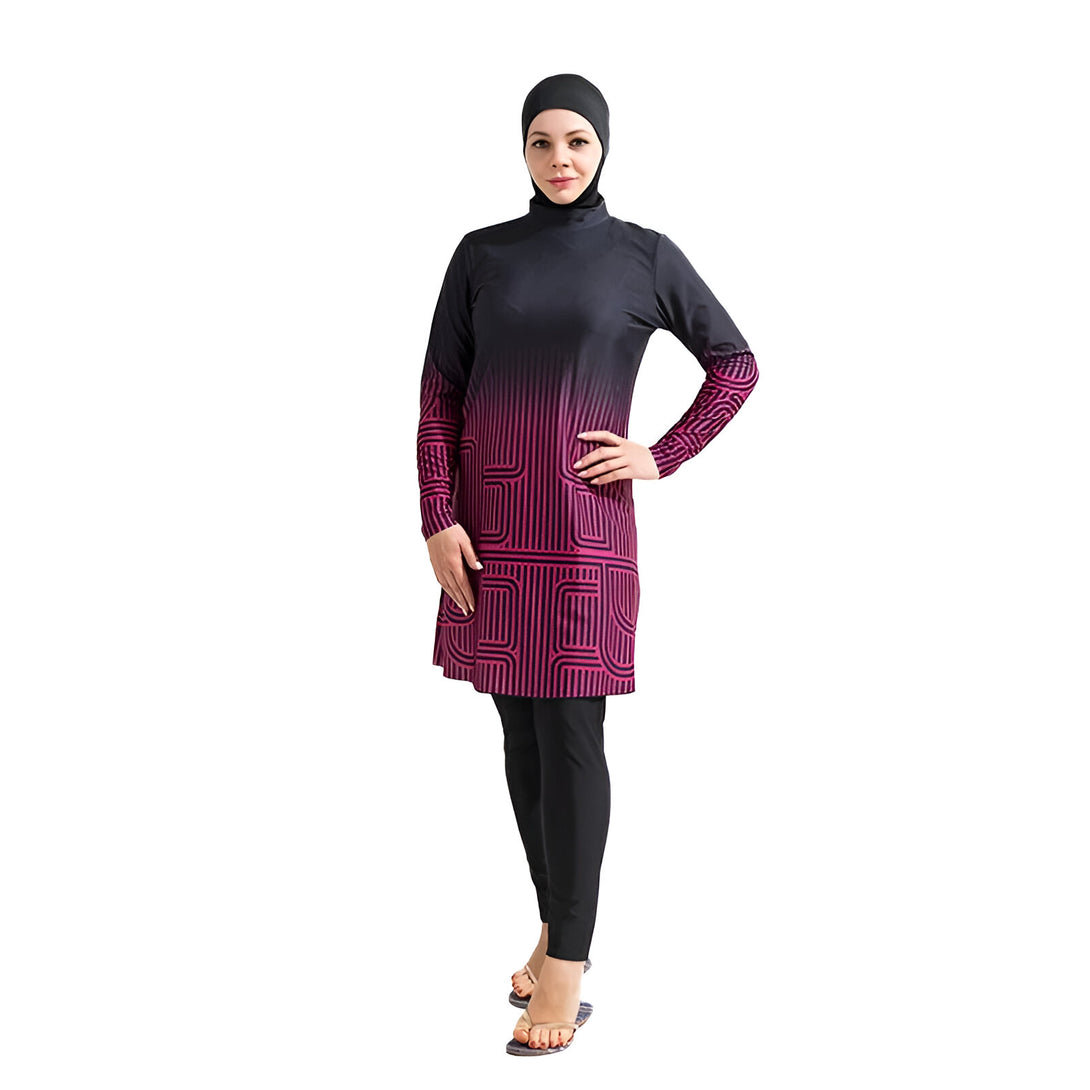 Une femme portant un maillot de bain musulman noir et rose avec un motif géométrique. Le maillot de bain a des manches longues et une jupe longue. La femme porte un hijab noir.