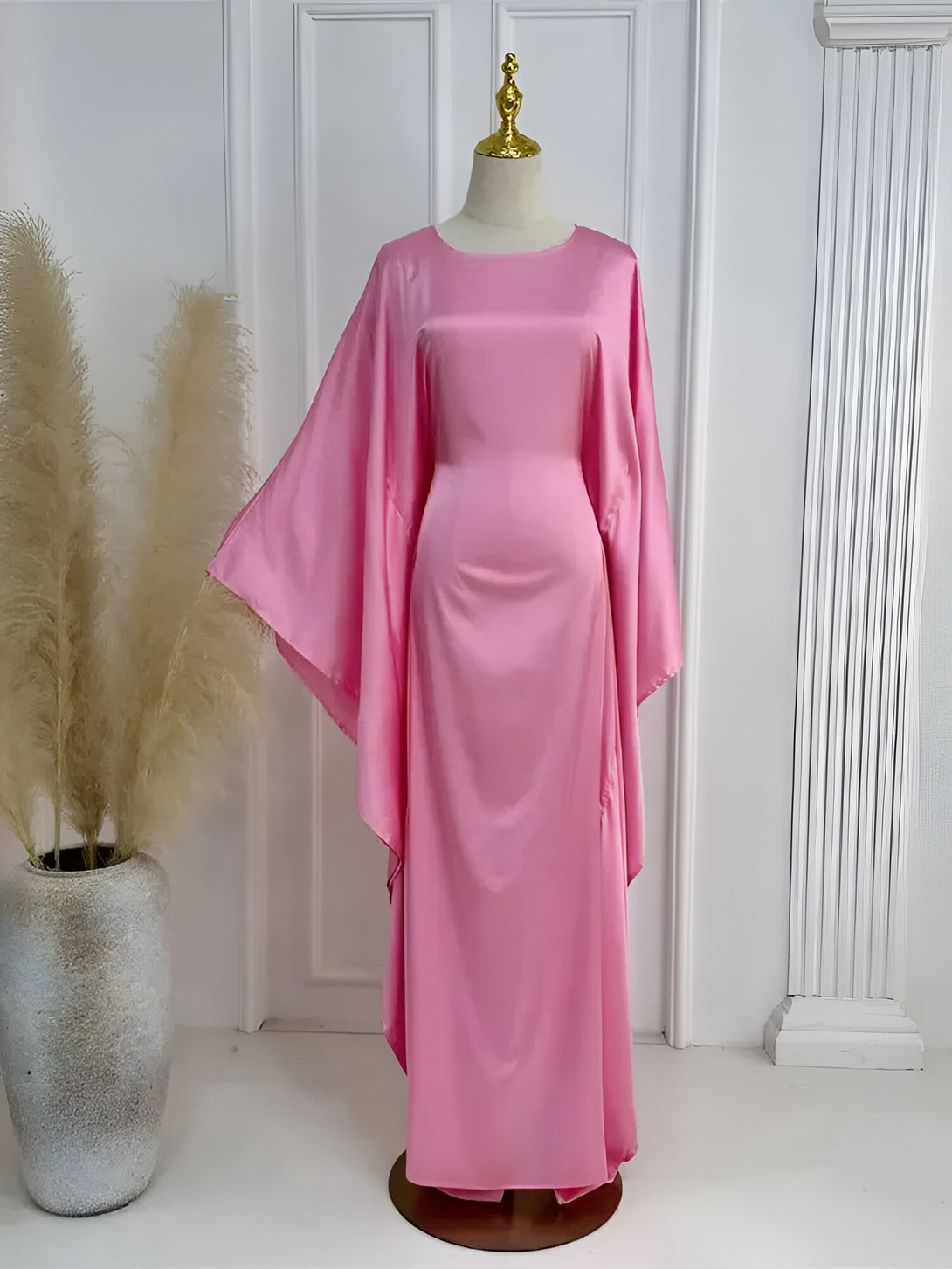 Robe longue rose en satin, idéale pour les occasions spéciales. Cette robe élégante et confortable est parfaite pour les femmes musulmanes qui recherchent un style chic et modeste.