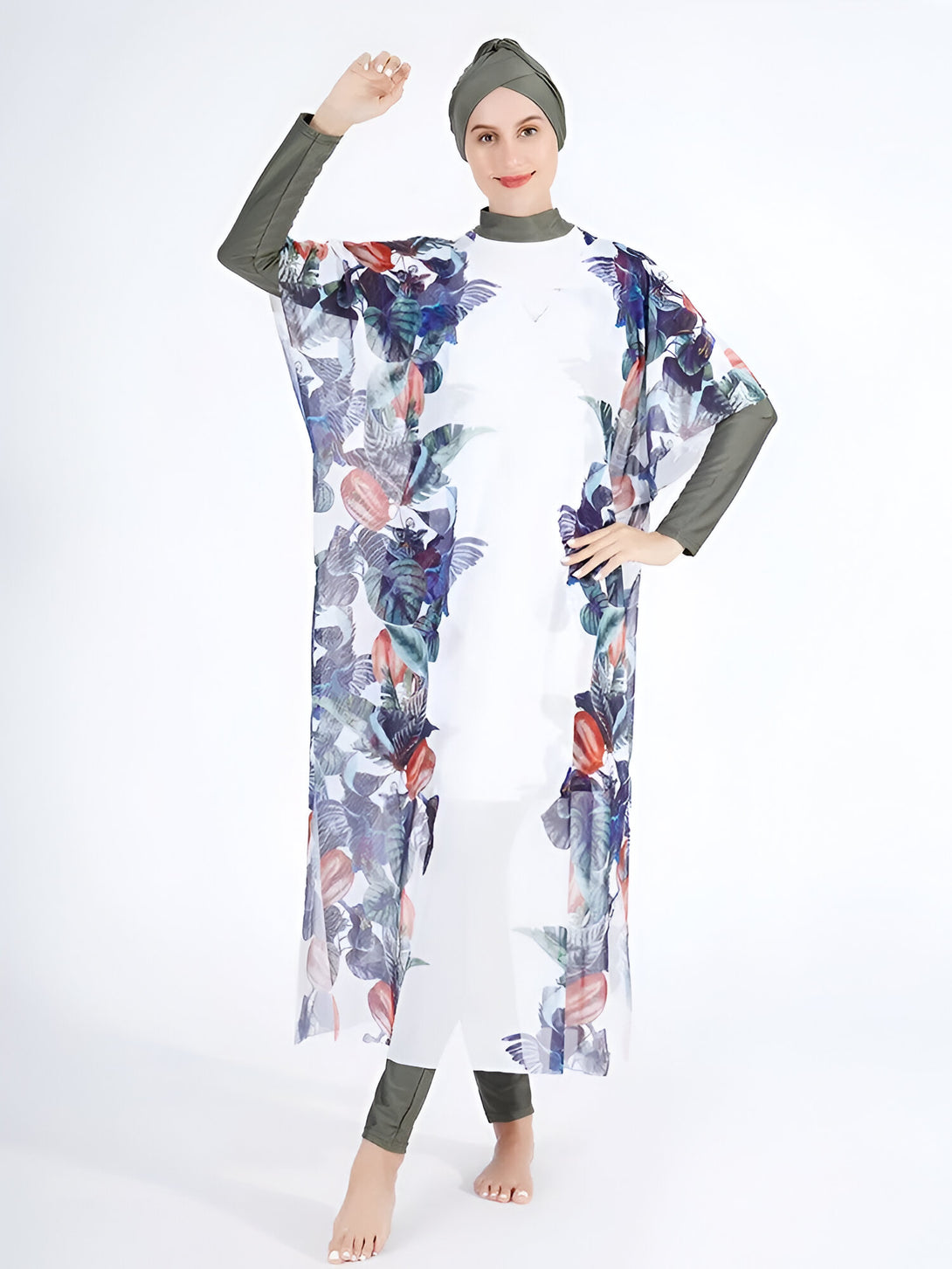 Une femme portant un maillot de bain musulman blanc avec un imprimé floral, un hijab vert et une robe transparente à manches longues.  Le maillot de bain est idéal pour la natation et la plage.