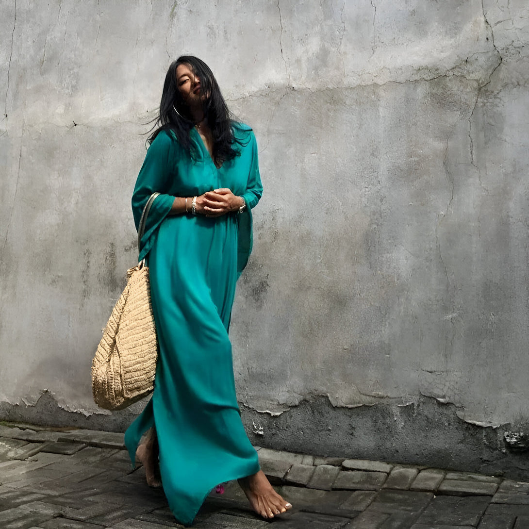 Une femme élégante portant une longue robe turquoise, idéale pour les occasions spéciales ou pour une tenue quotidienne chic.